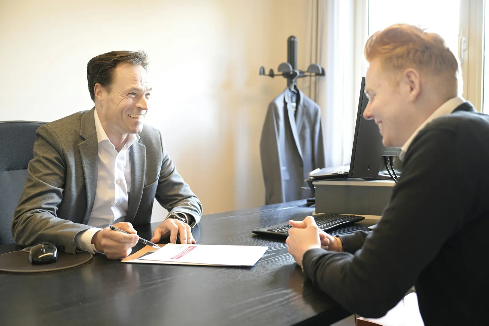 A Gold Collect collector and a seller going through the paperwork together at a desk